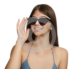 Teenage girl with sun protection cream on her nose against white background