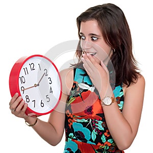 Teenage girl with a surprised expression checking the time on a big clock