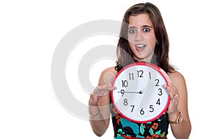 Teenage girl with a surprised expression showing the time on a big clock