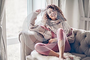 Teenage girl in sweater and jumpsuit on a couch