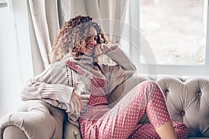 Teenage girl in sweater and jumpsuit on a couch