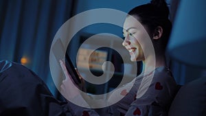 teenage girl with tablet pc in bed at night