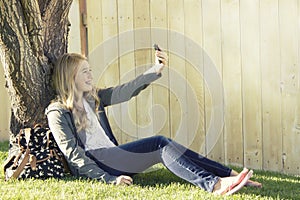 Teenage girl taking a selfie with a cell phone