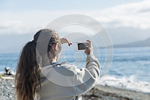 Teenage girl taking a selfie with her phone in Alaska