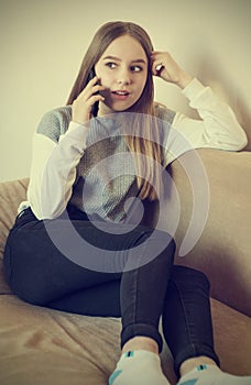 A teenage girl is talking on the phone