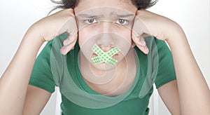 Teenage girl with taped mouth photo