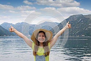 Teenage girl with thumbs up on vacation Kotor bay Montenegro