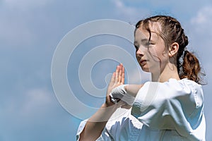 Teenage girl training karate kata outdoors, greetings oss photo