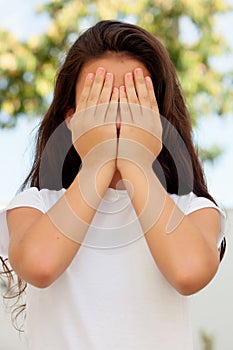 Teenage girl with twelve years old covering her face