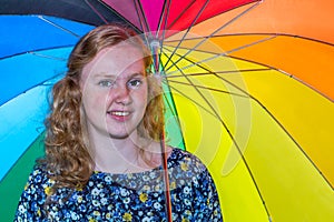 Teenage girl under colored umbrella