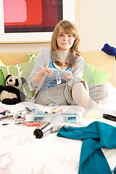 Teenage Girl In Untidy Bedroom Waxing Legs photo