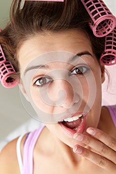 Teenage girl using curlers in her hair