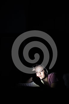 Teenage girl using her cell phone at night