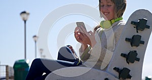 Teenage girl using mobile phone at beach 4k