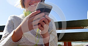 Teenage girl using mobile phone at beach 4k