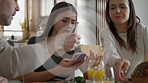Teenage girl using mobile phone during breakfast at the table.