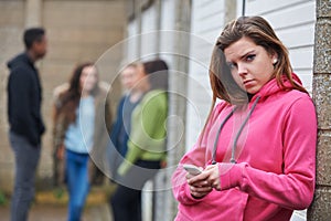 Teenage Girl Using Mobile Phone In Urban Setting