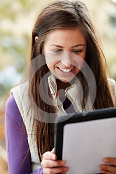 Teenage Girl Using Tablet Computer Outdoors