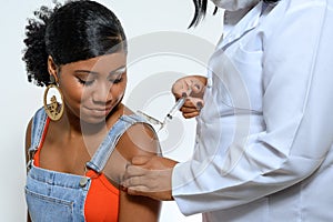 Teenage girl is vaccinated by health professional photo