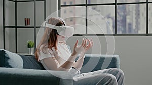 Teenage girl in virtual reality glasses examines fingers