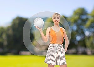 Teenage girl with volleyball over summer park