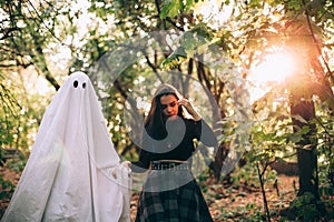 Teenage girl walking by the hand with ghost in forest