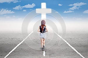 Teenage girl walking to the cross