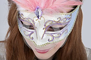 Teenage girl wearing carnival mask