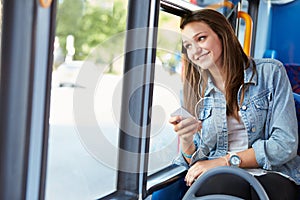 Teenage Girl Wearing Earphones Listening To Music On Bus photo