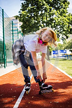 Teenage Girl Wearing Roller Skaters While Standing On The Road In Summe Park.