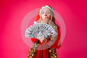 A teenage girl, wearing a Santa hat and tinsel around her neck,