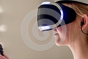 A teenage girl wearing VR glasses headset . Virtual reality simulator technology. Gaming