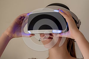 A teenage girl wearing VR glasses headset . Virtual reality simulator technology. Gaming