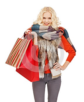 Teenage girl in winter clothes with shopping bags