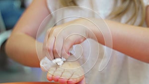 Teenage girl wipes her hands with a damp cloth after eating in a cafe.