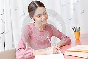 Teenage girl writing in her exercise book