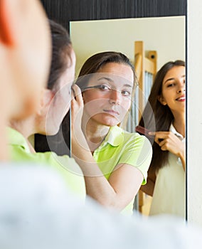 Teenage girlfriends having fun near mirror