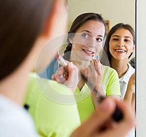 Teenage girlfriends having fun near mirror
