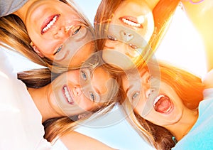 Teenage girlfriends staying together over blue sky