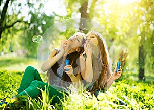 Teenage girls blowing soap bubbles