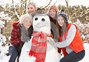 Teenage Girls Building Snowman