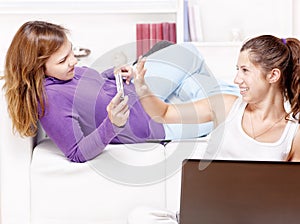 Teenage girls having fun using electronic gadgets