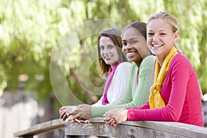 Teenage Girls Leaning On Wooden Railing