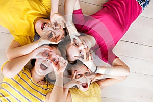 Teenage girls making faces on  floor