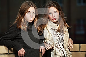 Two fashion teen girls on night city street