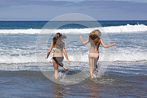 Teenage Girls Running into the Ocean at the Beach