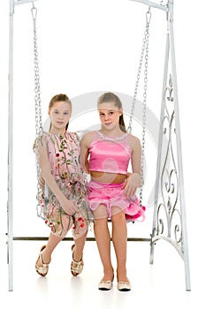 Teenage Girls Sitting Together on Elegant Metal Swing
