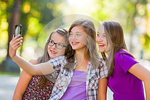 Teenage girls taking selfie in park