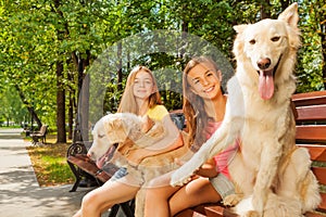 Teenage girls with their dogs on the park bench