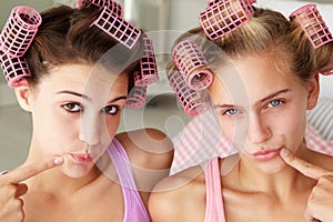 Teenage girls using curlers in their hair